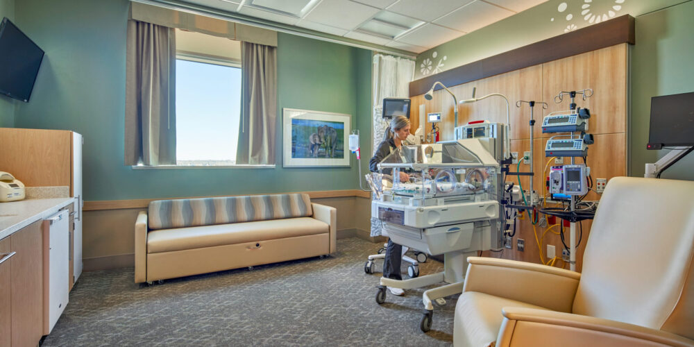 Nurse in patient room overlooking incubator